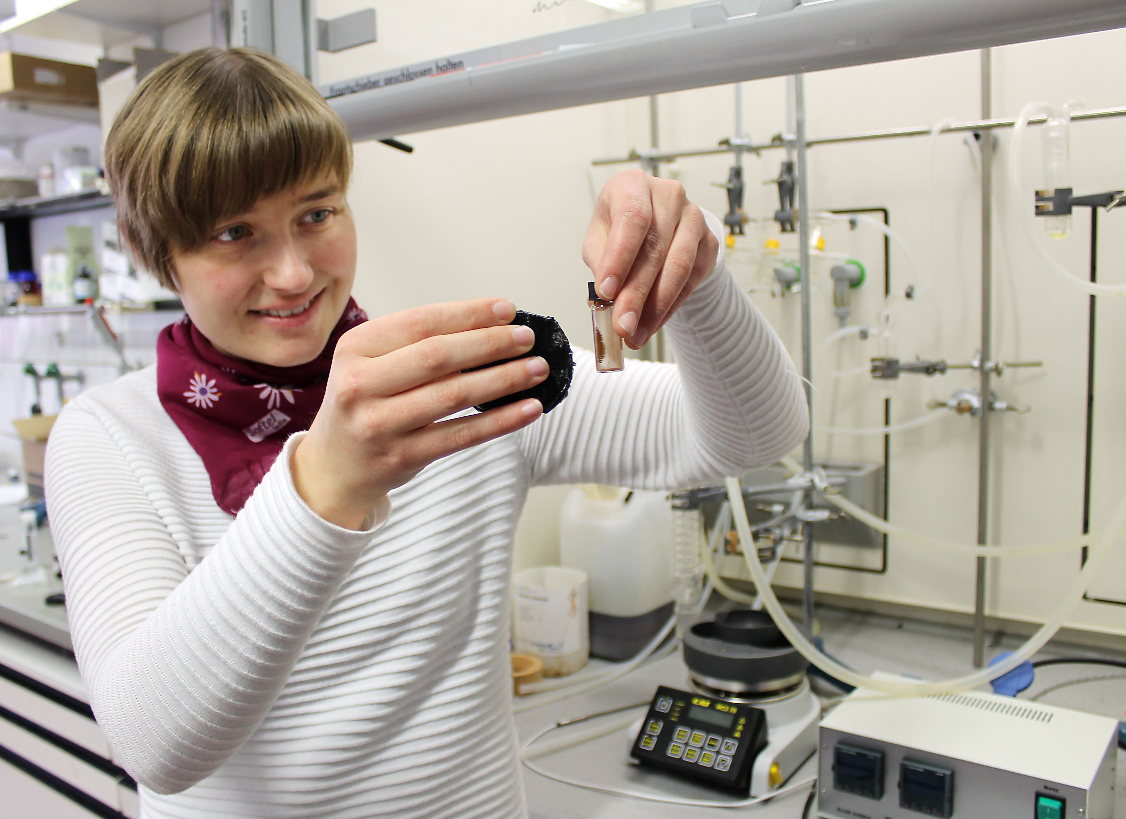 Frau demonstriert das Verhalten magnetischer Nanopartikel in der Hand