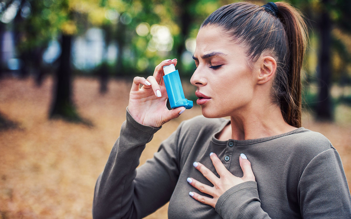 Frau nutzt Asthma-Inhalator.
