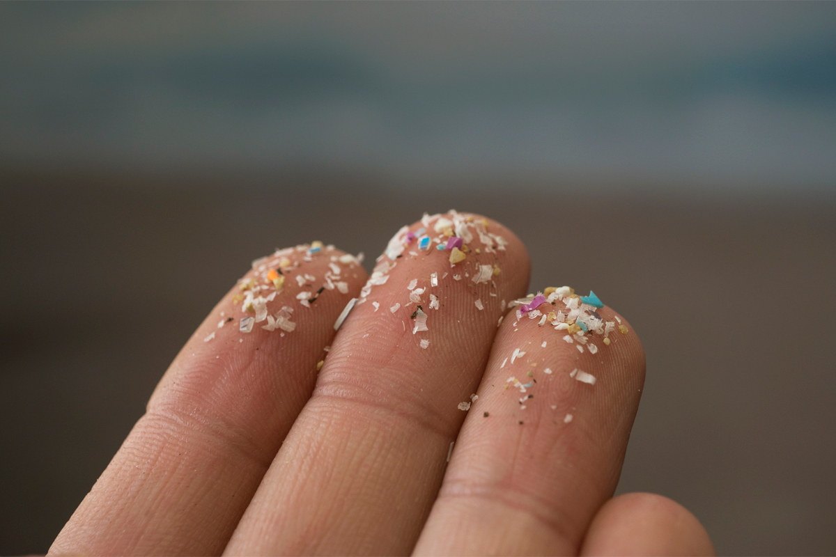 Mikroplastik auf Fingern.