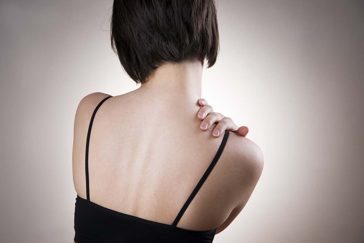 Frau mit Schmerzen im Schulter-Rücken-Bereich.