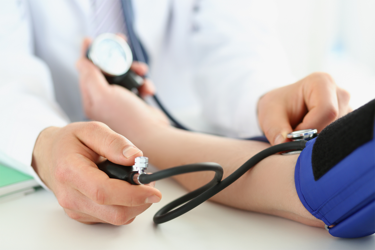 Arzt misst Blutdruck bei Patienten.