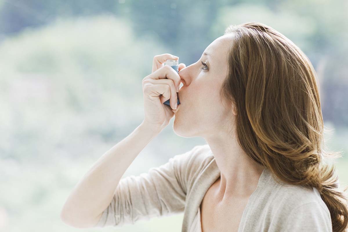 Frau nutzt Asthma-Inhalator