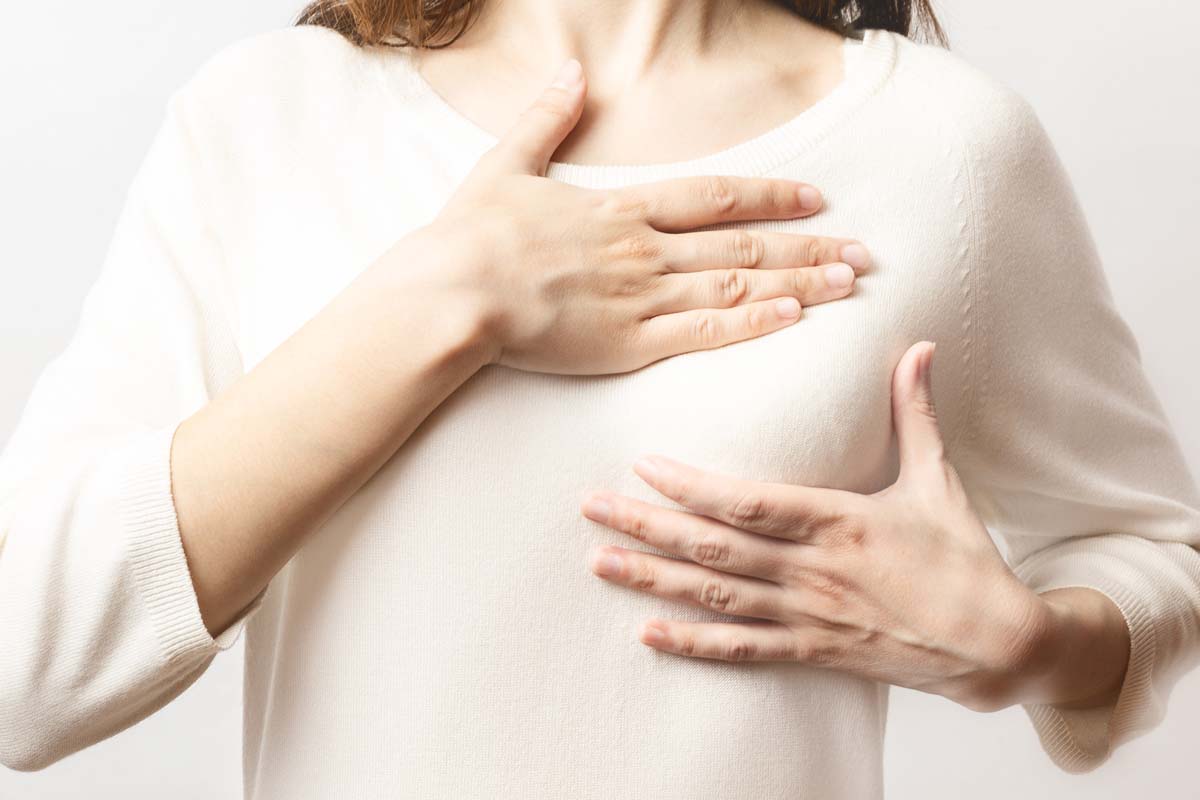 Frau untersucht Brustgewebe nach Knoten